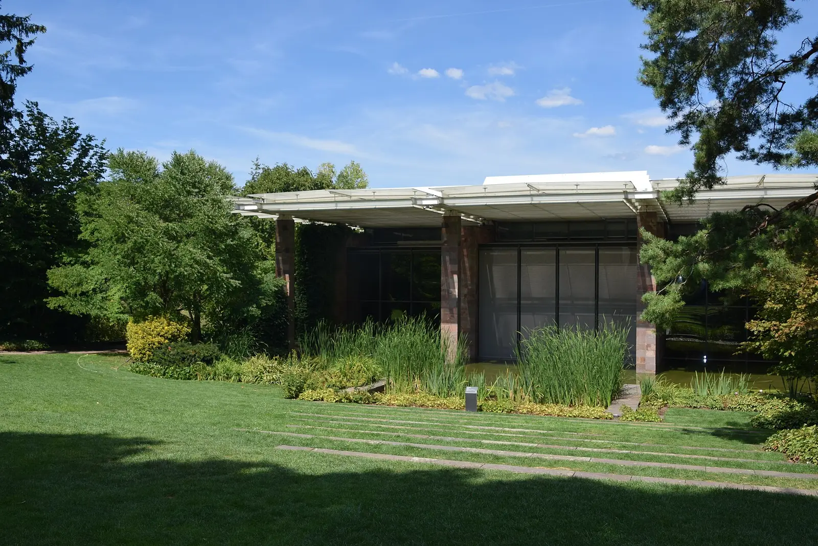 Fondation Beyeler museum pavilion seen across its lawn and trees