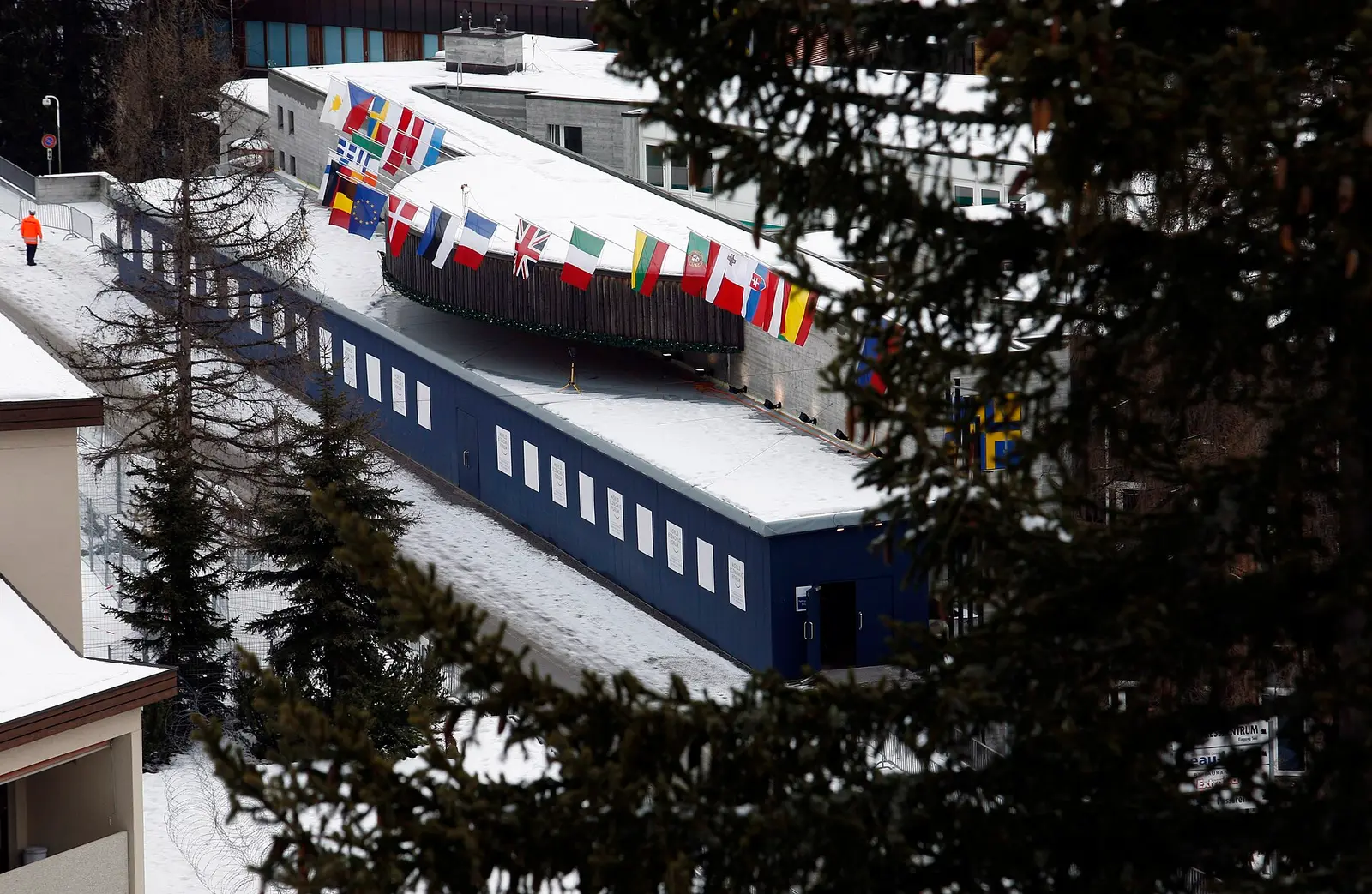 Snow-covered Davos Congress Centre with international flags on the roof