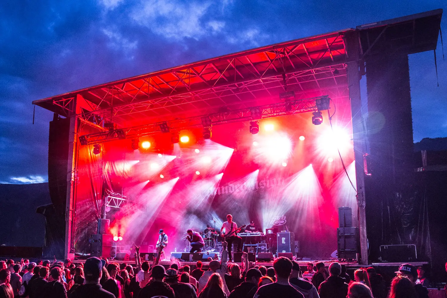 Red lit stage and crowd at the Greenfield Festival near Interlaken at dusk