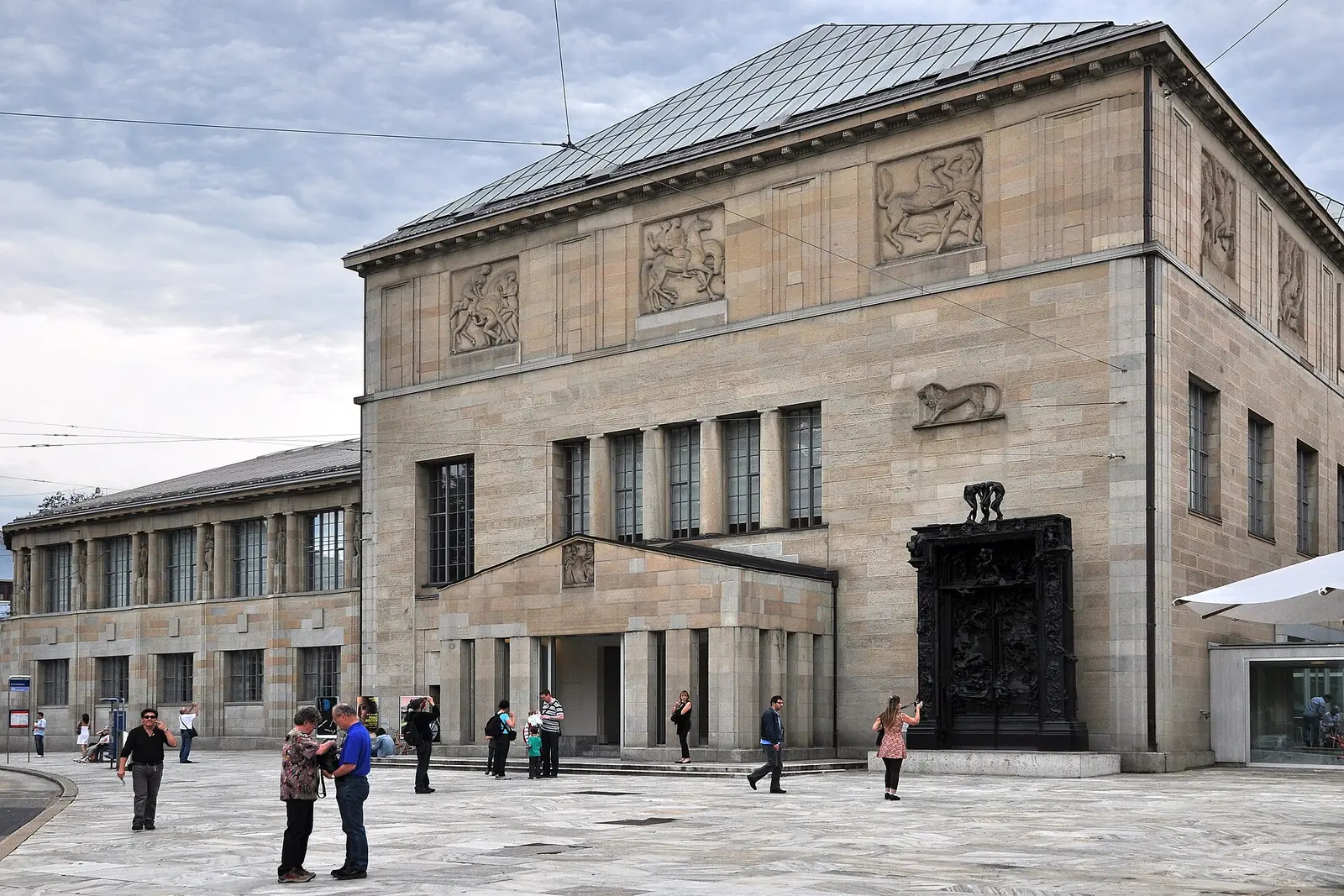 Stone facade of the Kunsthaus Zürich with visitors on the forecourt